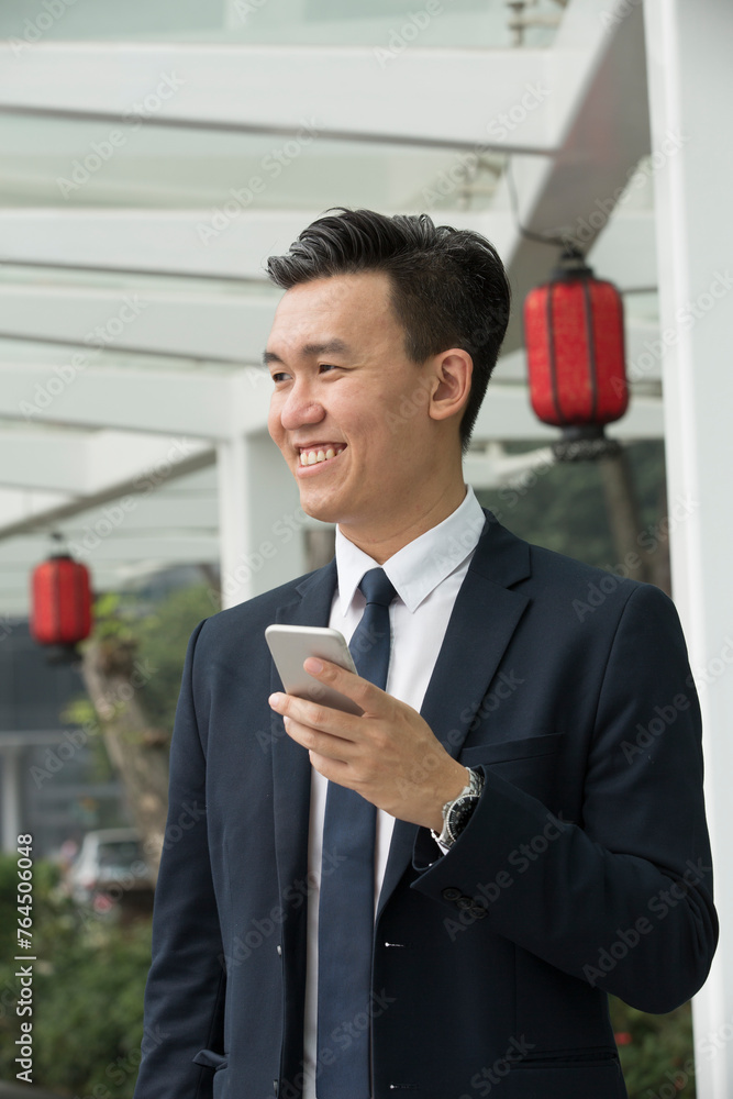 Asian business Man using his Smart phone outdoors. Asian business Man using his Smart phone outdoors.