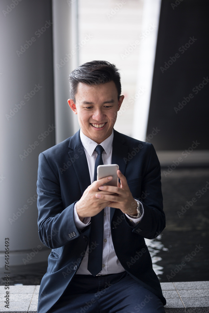 Asian business Man using his Smart phone outdoors. Asian business Man using his Smart phone outdoors.