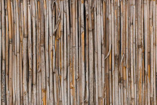 The texture of the dry reeds, fence, roofing material