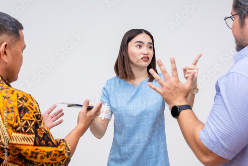 Foto A stressed female traveler holds her passport and boarding pass while two men attempt to reason and calm her down in an indoor setting