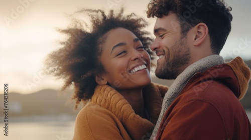 A young interracial couple in love, having fun and embracing on an autumn day at the beach, colors of diversity and love,copy space