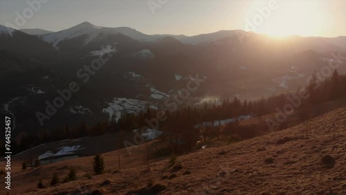 Group of friends admire setting sun in the mountains.