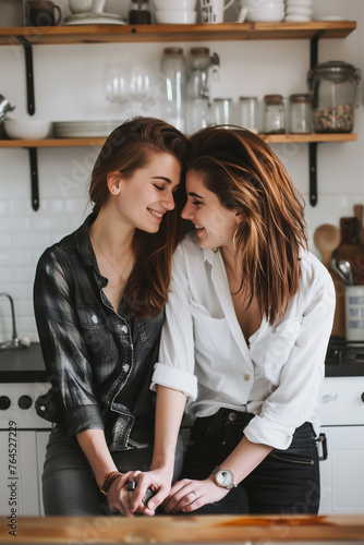 Joyful lesbian couple sharing love and joy in a white kitchen