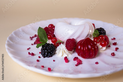 White cream cake with fresh berries on white plate. Isolated on beige background photo