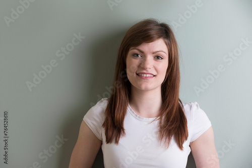Young woman standing on grey background © Image Smith