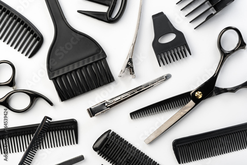 Black hairdressing tools and various hairbrushes on white background