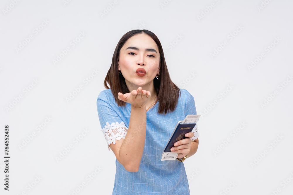 Asian woman blowing a kiss with passport and boarding pass in hand, isolated on white Asian woman blowing a kiss with passport and boarding pass in hand, isolated on white