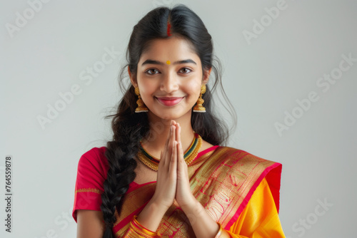 Smiling young Indian female wearing sari showing namaskar gesture