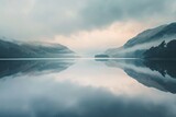 Soft pastel hues reflecting off a tranquil lake under a moody sky