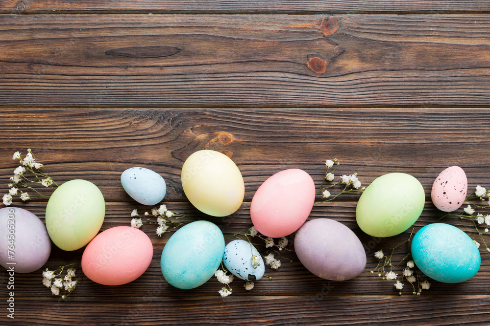 Happy Easter composition. Easter eggs on colored table with gypsophila. Natural dyed colorful eggs background top view with copy space
