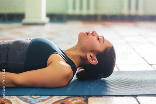 yoga practitioner in a neckstretch pose on a mat photo