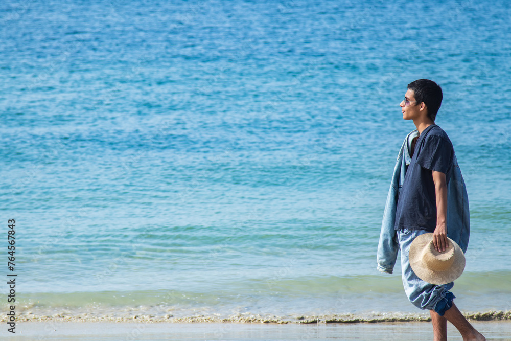 young man walking relaxed on the beach young man walking relaxed on the beach