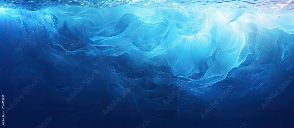 Obraz premium A mesmerizing view of a blue ocean with a wave and bright light emanating from the water, creating a serene and peaceful scene