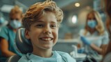 Portrait of a happy young boy with a toothy smile sitting on the dental chair