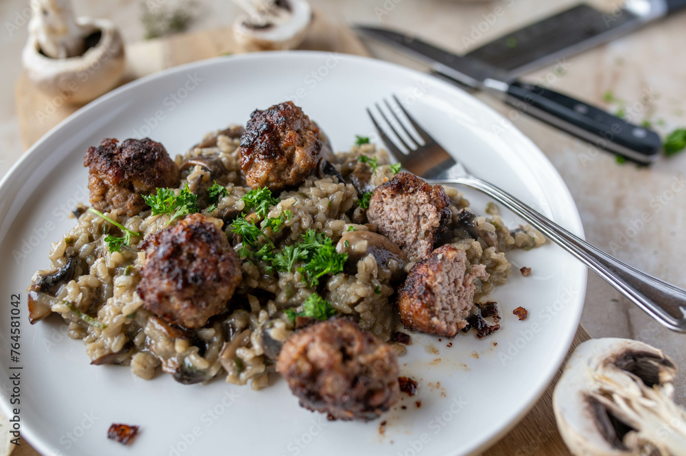 Risotto with mushrooms and swedish meatballs or köttbullar on a plate