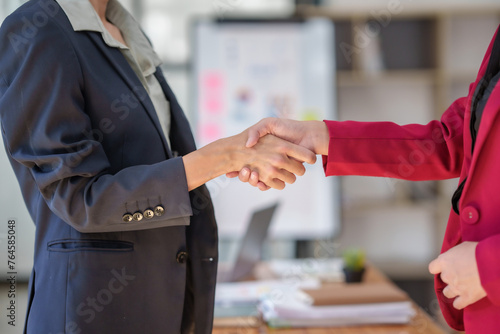 Two women shaking hands in a business setting