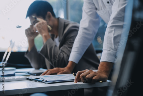 Young stressed Asian businessman working in the office. Businessman thinking too much work concept in the office. © ARMMY PICCA