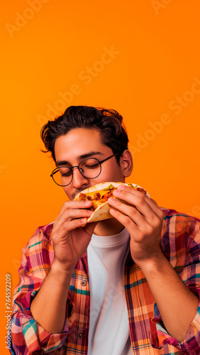 Mexican man eating mexican taco over yellow background with copy space.