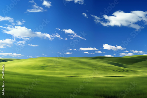 A beautiful, perfect landscape with green grass on hills and green fields. The sky is filled with white clouds and bright sunlight. There are also shadows that create a sense of depth and realism. © soleg