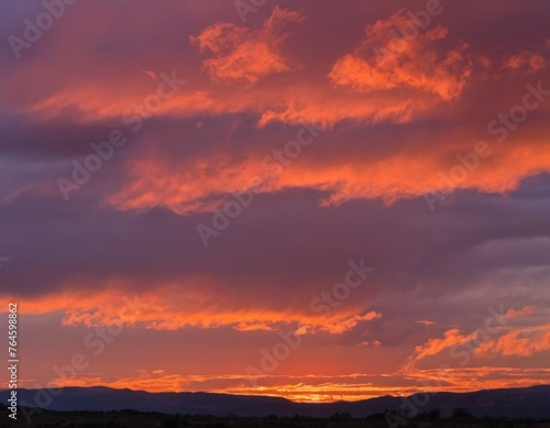 Dramatic sunset with fiery clouds over a serene countryside landscape. © Liera