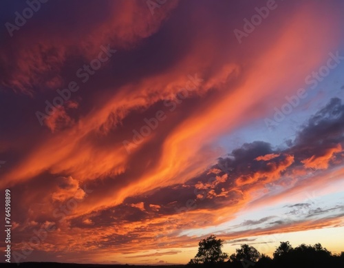 Dramatic sunset with fiery clouds over a serene countryside landscape.