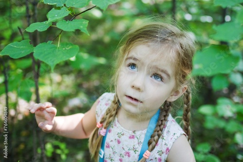Innocence Captured Curious Little Girl in Awe of Majestic Tree, a Heartwarming Moment.