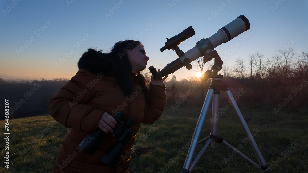 Amateur astronomer observing skies with binoculars and telescope
