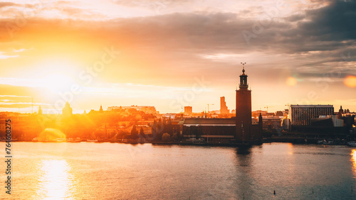 Stockholm, Sweden. Scenic Skyline View Of Famous Tower Of Stockholm City Hall. Building Of Municipal Council Stands On Kungsholmen Island. Sunshine Above Famous And Popular Place In Sunset Sunrise.