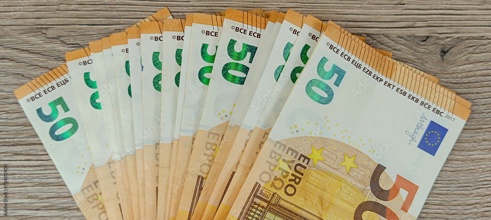 liasse de billets de banque de 50 euros, en gros plan, sur une table - obrazy, fototapety, plakaty 
