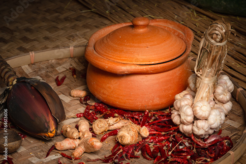 Still life of dry spices herbs in palm paper tray and glay pot oriental cooking photo