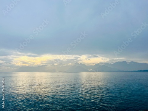 Fantastic seascape background, bright cloudy sky reflection on the blue sea surface, blue sea horizon background