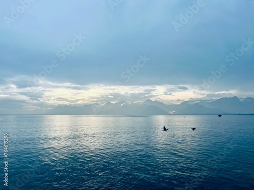 Fantastic seascape background, bright cloudy sky reflection on the blue sea surface, blue sea horizon background