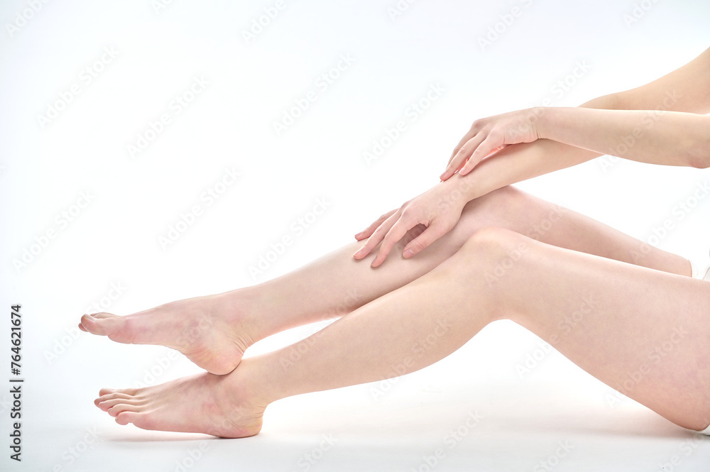 Isolated on the legs, hands and white background of a young Asian woman on a diet. Isolated on the legs, hands and white background of a young Asian woman on a diet.