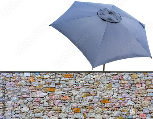 Parasol de jardin derri  re mur de pierres apparentes  fond blanc 