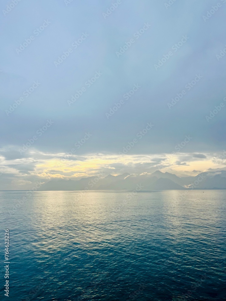 Fantastic seascape background, bright cloudy sky reflection on the blue sea surface, blue sea horizon background