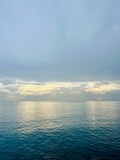 Fantastic seascape background, bright cloudy sky reflection on the blue sea surface, blue sea horizon background