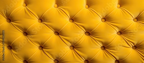 An image showing a detailed view of a couch with yellow leather upholstery.
