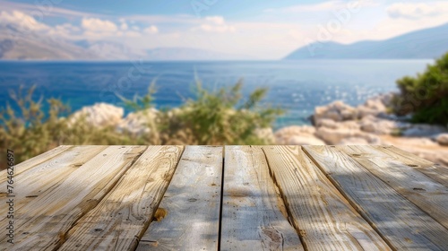 Empty wooden table top with a blur view of the coastline of a Greek island 