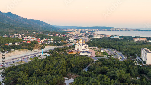 Gelendzhik, Russia. Cathedral of St. Andrew the First-Called. The text at the entrance to the city is translated as Gelenzhik-City Resort. Sunset time, Aerial View © nikitamaykov