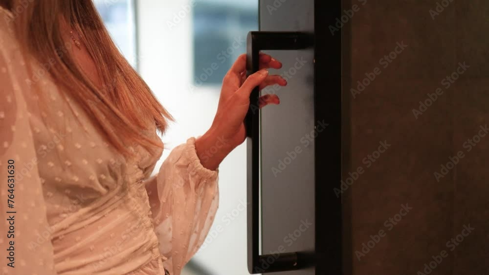 Close up view of unrecognizable woman in a hotel room walking through the corridor and opening another door Close up view of unrecognizable woman in a hotel room walking through the corridor and opening another door