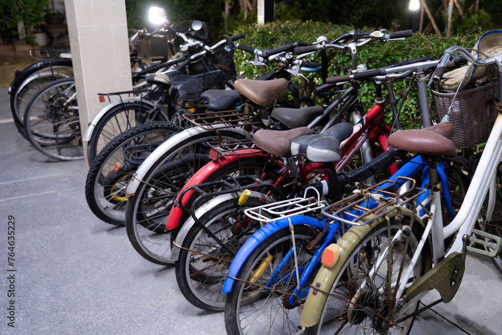 Several old bicycles lined up under the apartment building Several old bicycles lined up under the apartment building