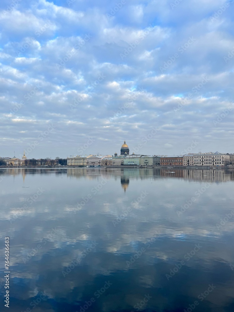 Fototapeta premium Amazing bright cloudy sky and buildings reflection at the city river 