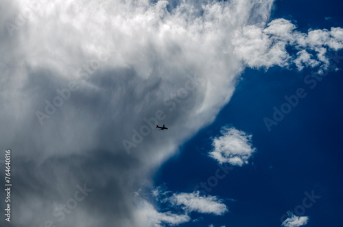 Airplane in the blue sky with white clouds. Cloudscape