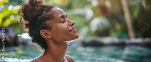 Lifestyle portrait of beautiful black woman relaxing in spa pool at luxury resort 