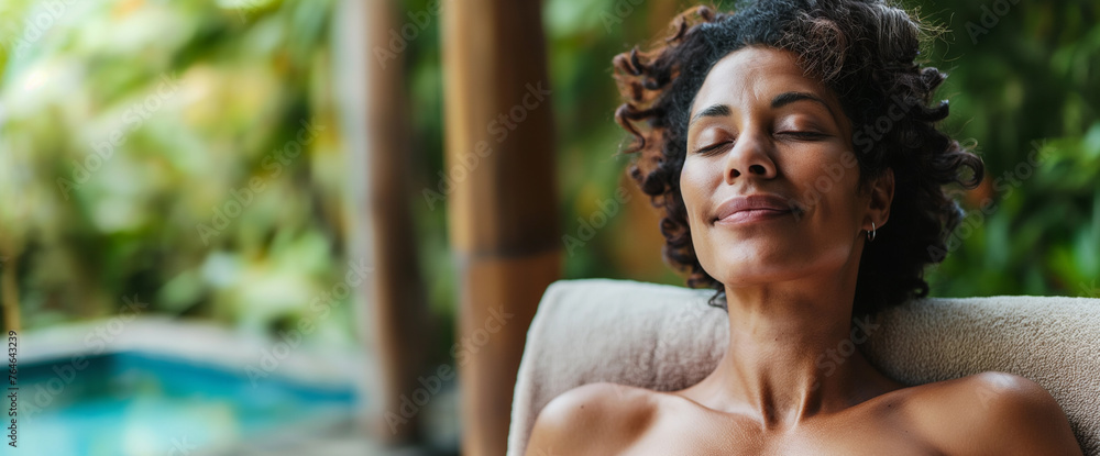 Lifestyle portrait of beautiful black woman relaxing by spa pool at luxury resort  - obrazy, fototapety, plakaty 