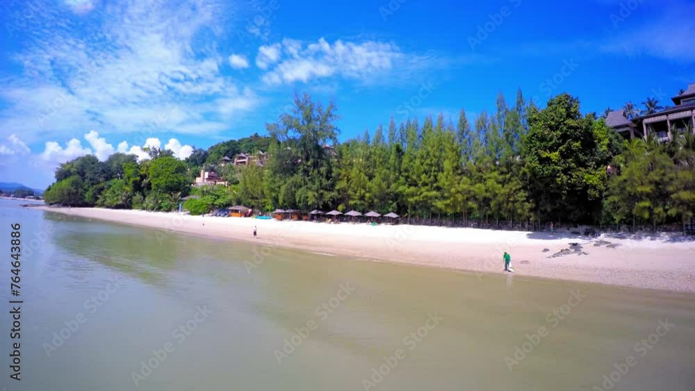 Aerial: Scenic View Of Parasols At Beach By Spa Resorts At Beach, Drone Flying Backwards Over Sea On Sunny Day - Krabi, Thailand Aerial: Scenic View Of Parasols At Beach By Spa Resorts At Beach, Drone Flying Backwards Over Sea On Sunny Day - Krabi, Thailand
