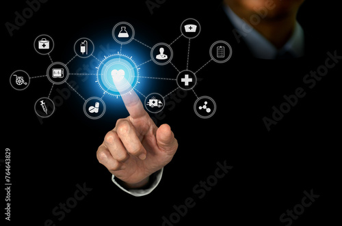 Businessman hand touching at heart icon and con medical connection with modern virtual screen interface, medical technology concept.