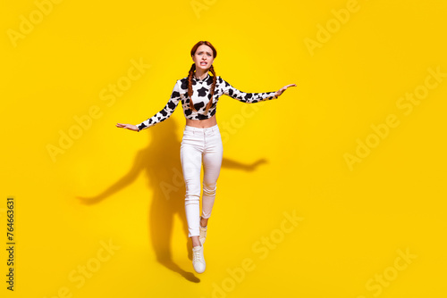 Full size photo of worried nervous girl jump walk empty space rope isolated on yellow color background