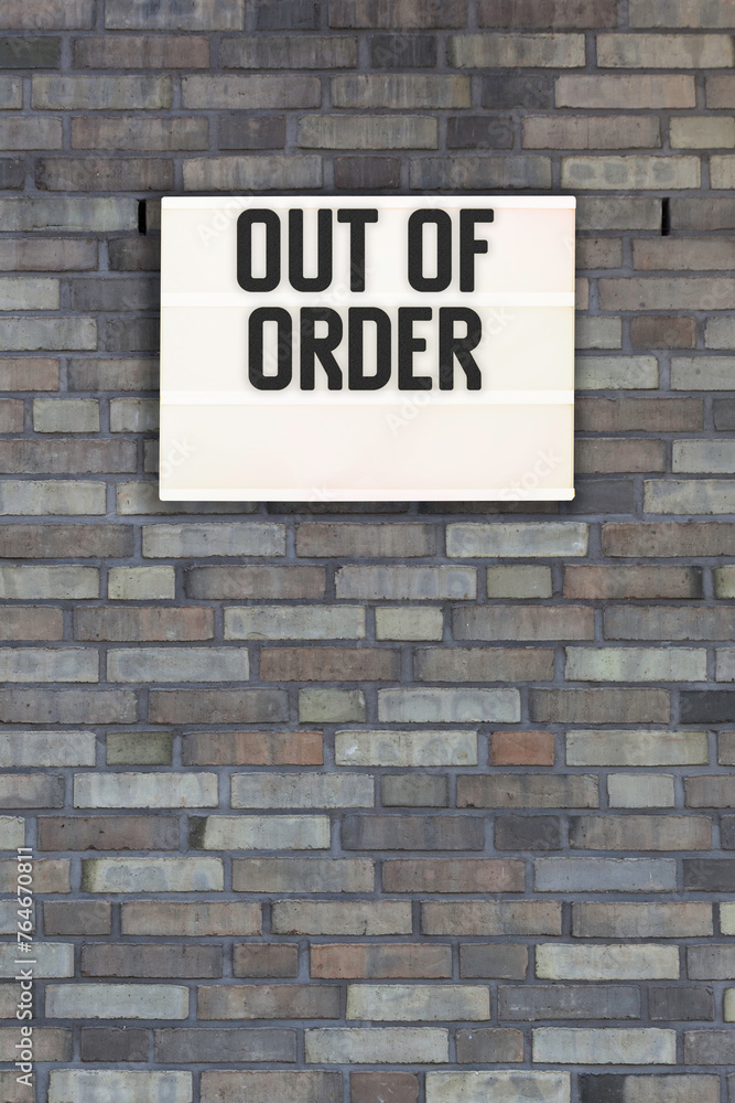Out of Order message in lightbox on brick wall Out of Order message in lightbox on brick wall