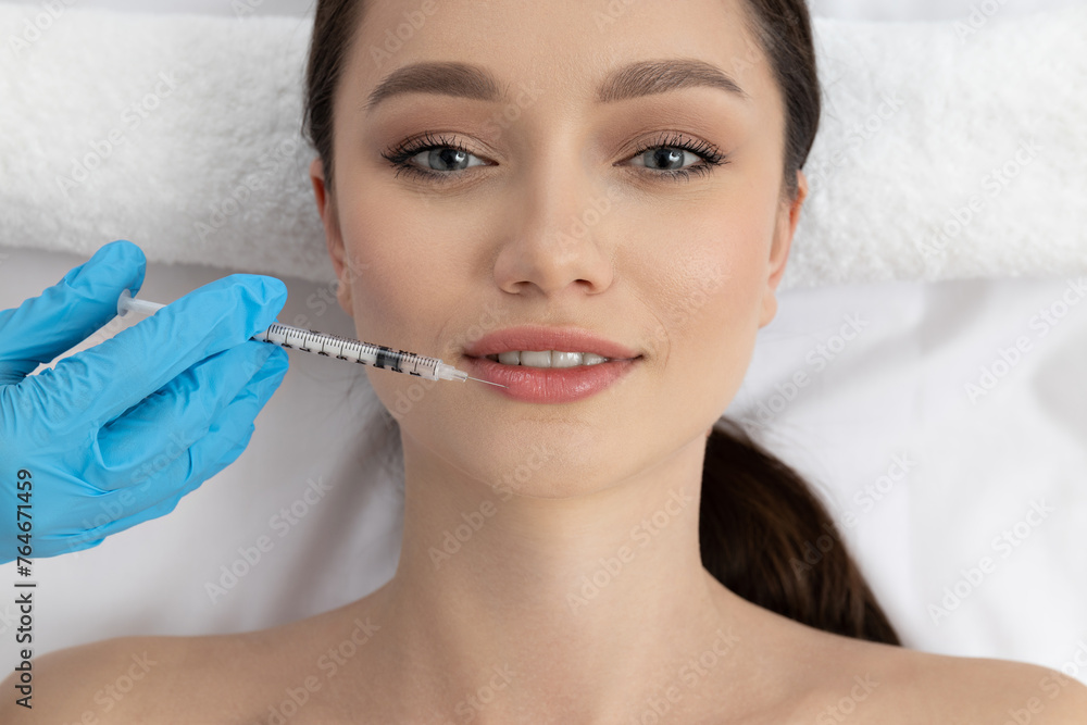 The doctor injects botox to a young girl The doctor injects botox to a young girl